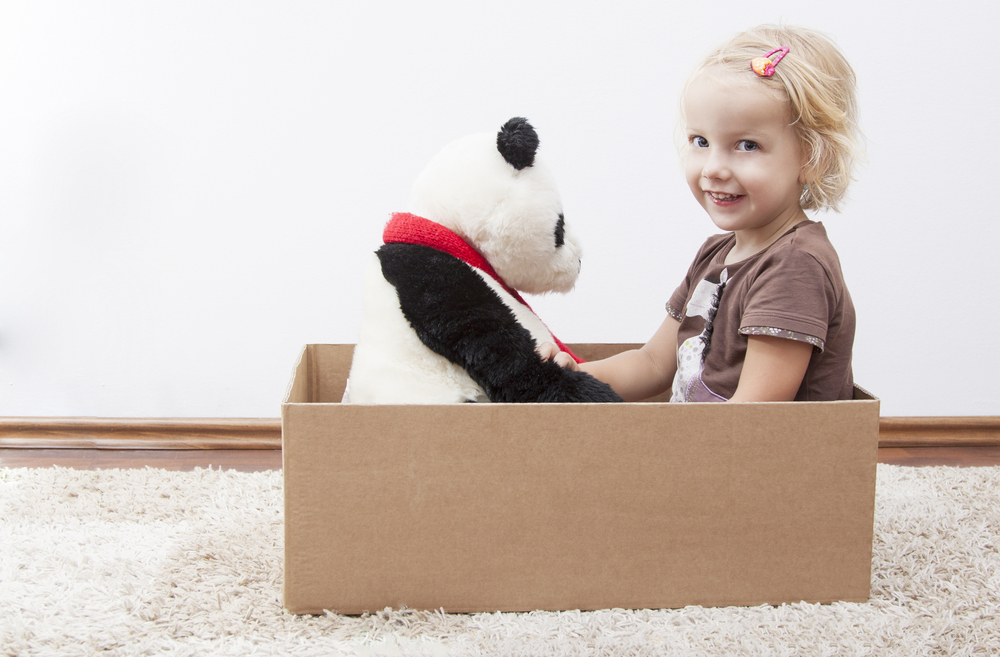 Девочка с игрушечным пандой в коробке