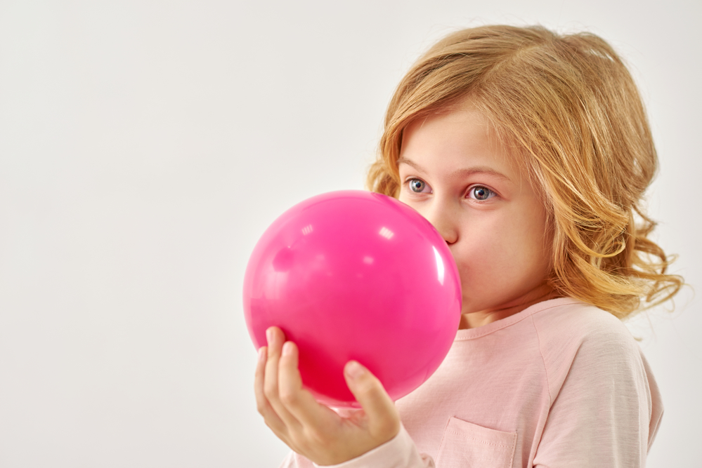 Дівчинка надуває кульку для лікування застуди