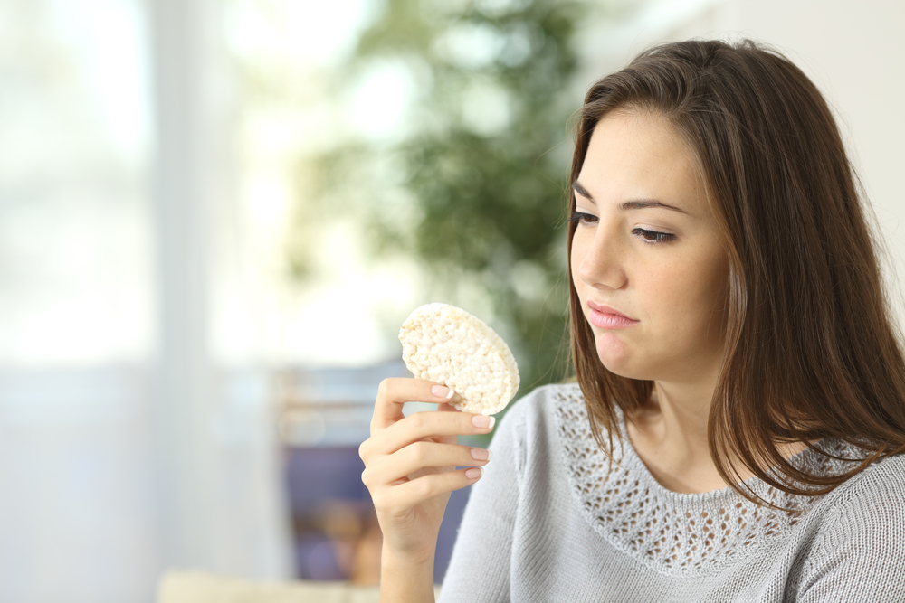 Девушка ест цельнозерновые диетические крекеры