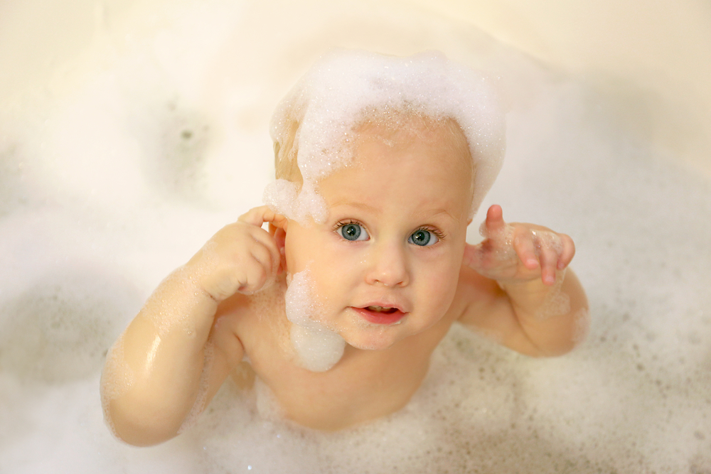 Малыш купается в ванне с пеной