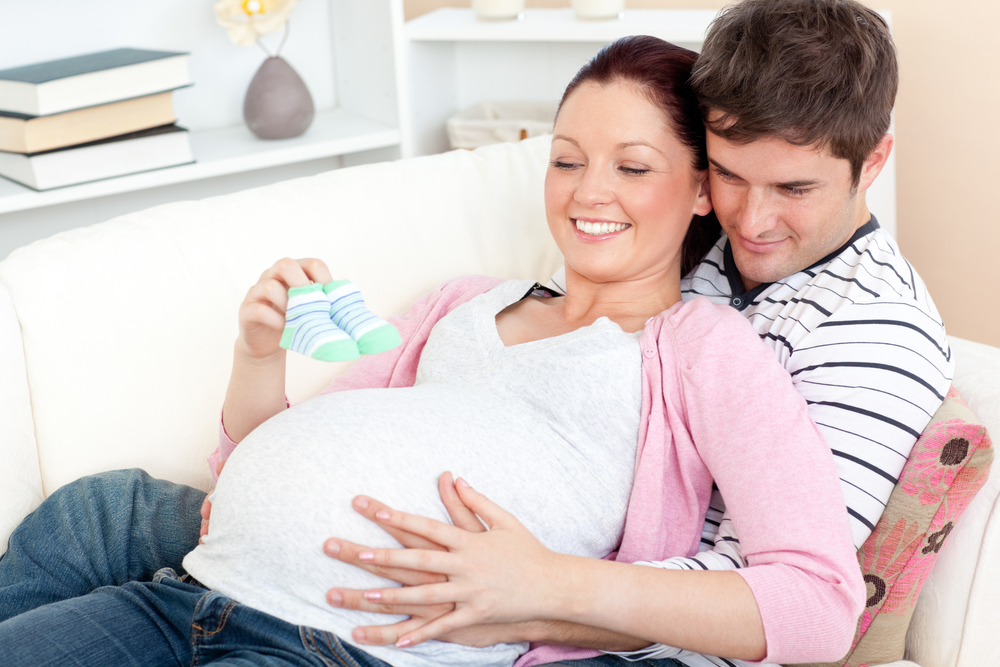 Беременная женщина с мужем на диване