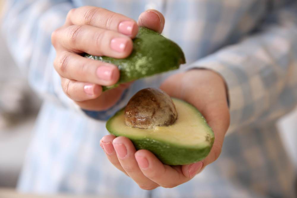 Женщина разделывает авокадо