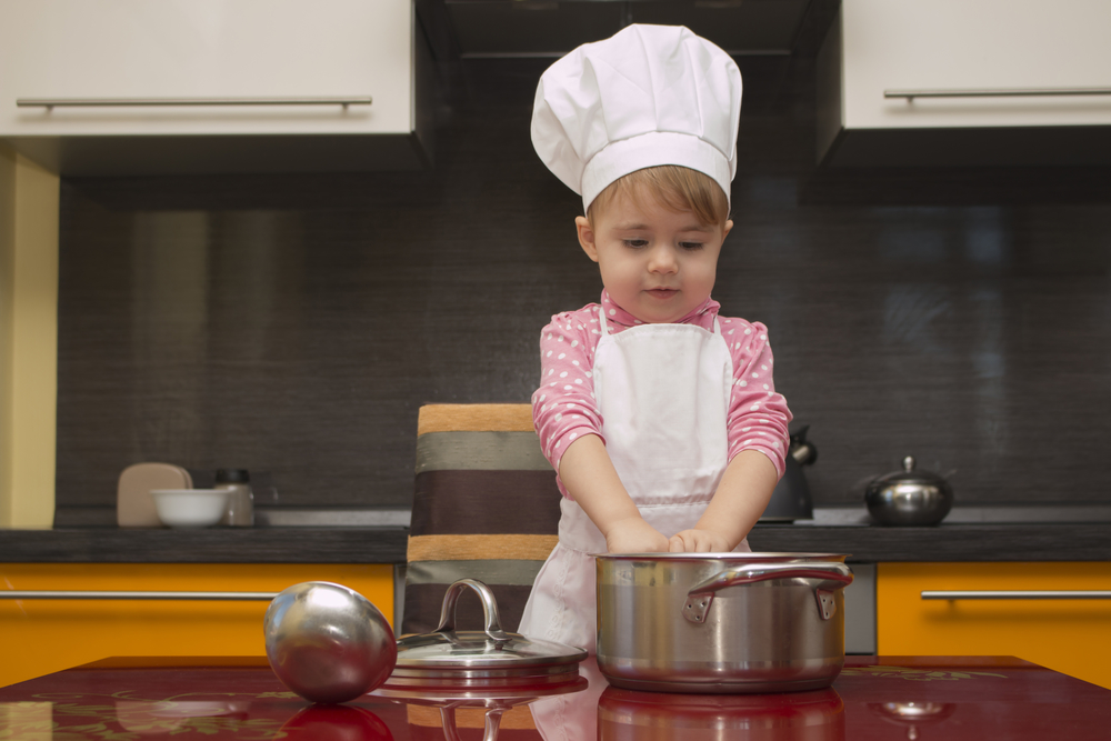 Дівчинка на кухні допомагає мамі готувати