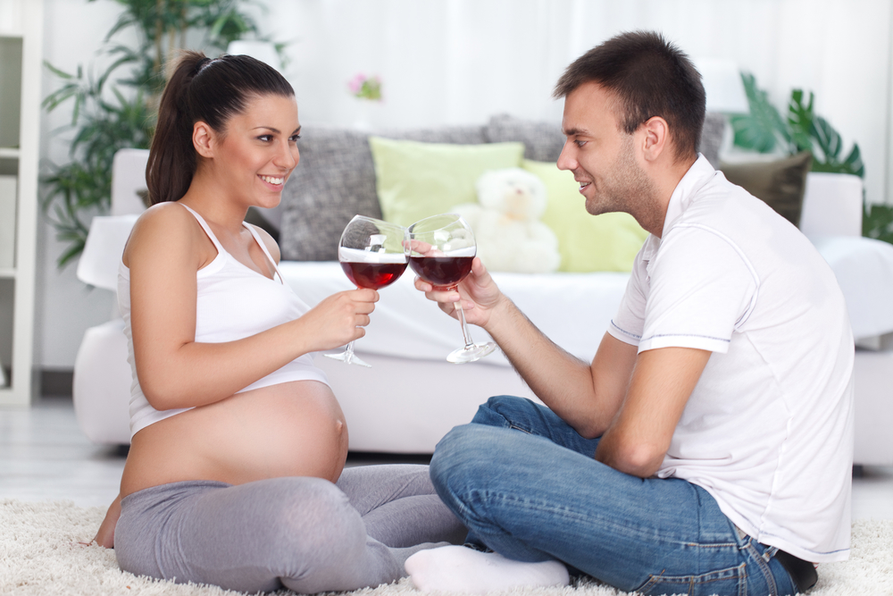 Беременная с мужем пьют вино