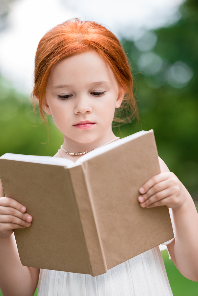 ​дівчинка читає книгу 