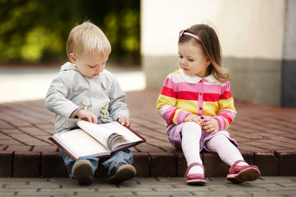 Мальчик с девочкой читают книгу