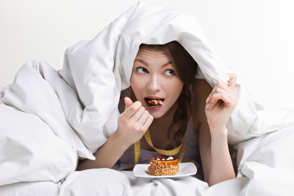 Женщина ест под одеялом - праздник  обжорства