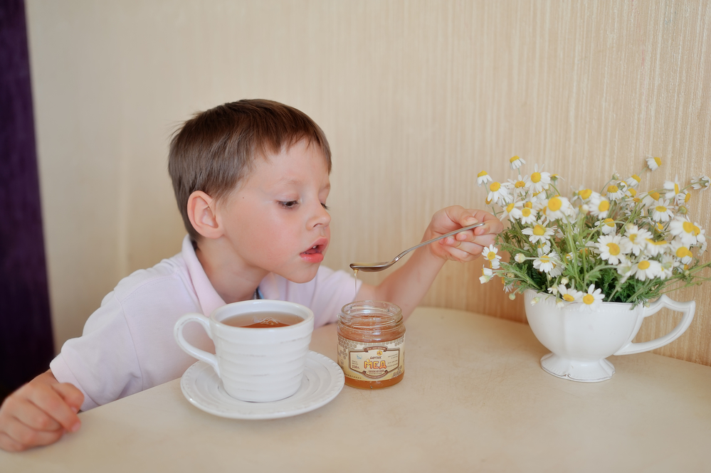 Ребенок пьет чай с медом