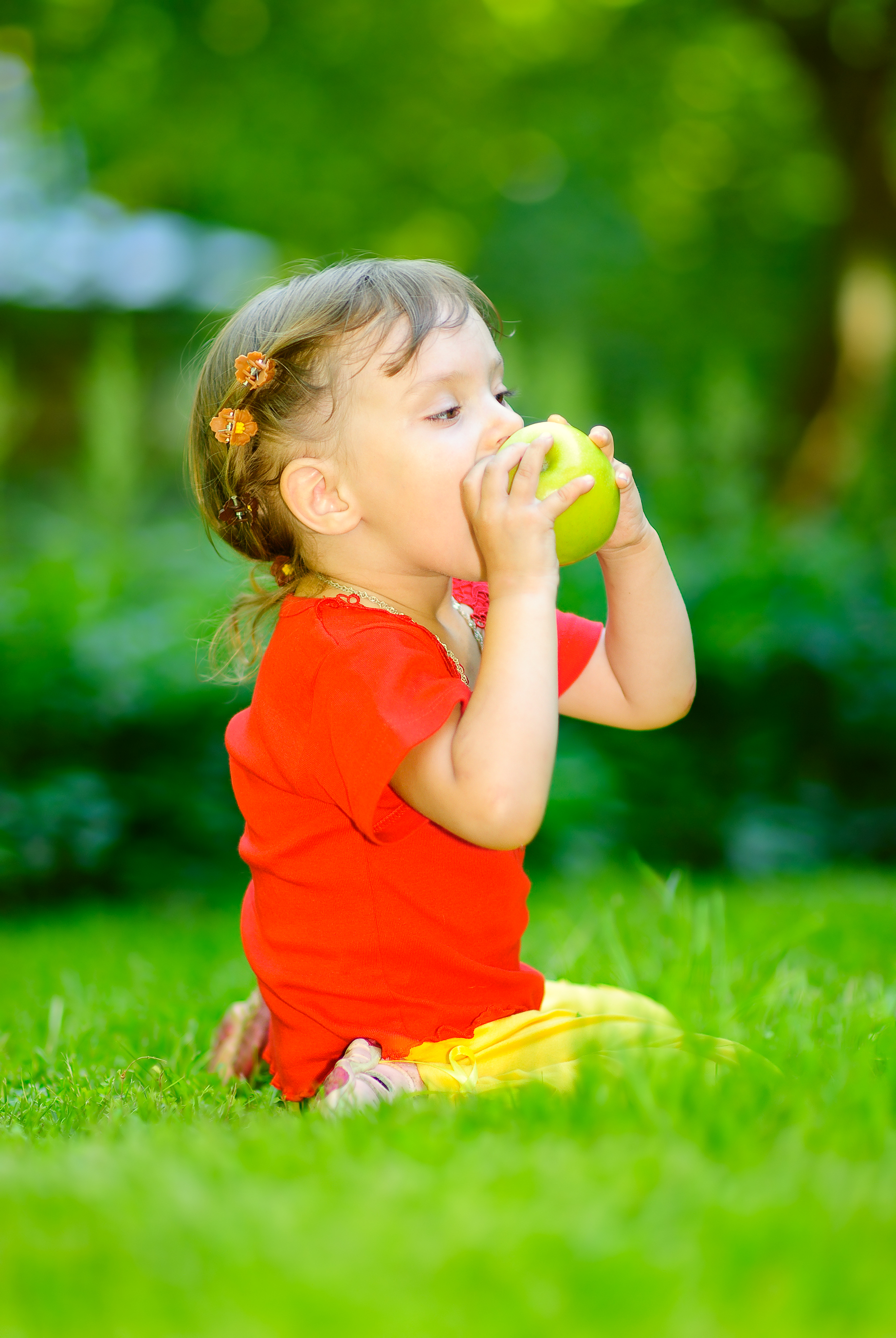 Ребенок ест зеленое яблоко для здоровья зубов