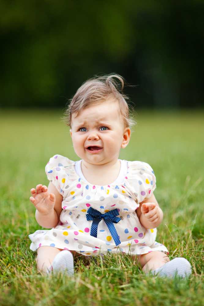 Дівчинка плаче сидячи на траві