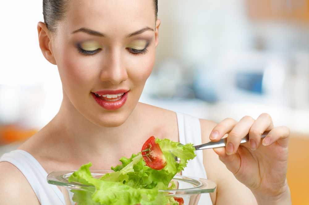 Жінка їсть салат з латуку