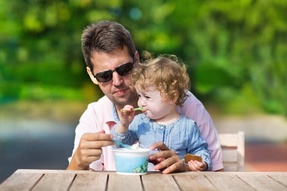 Дівчинка з татом їдять морозиво