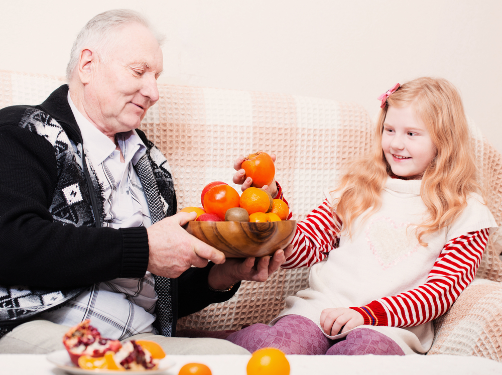 Дедушка и внучка едят хурму