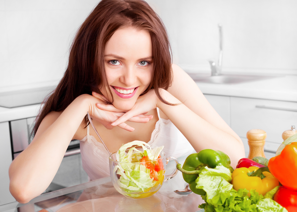 Женщина ест салат с оливковым маслом