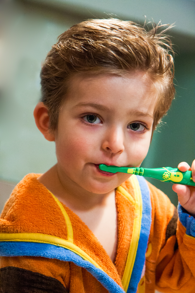 мальчик чистит молочные зубы