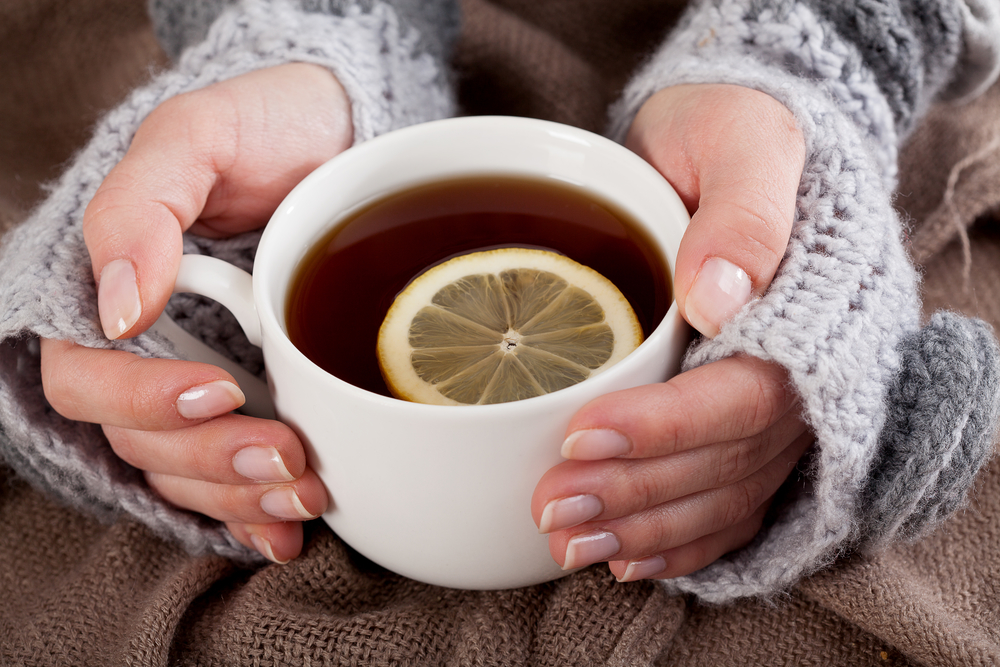 Женщина согревается чаем с лимоном