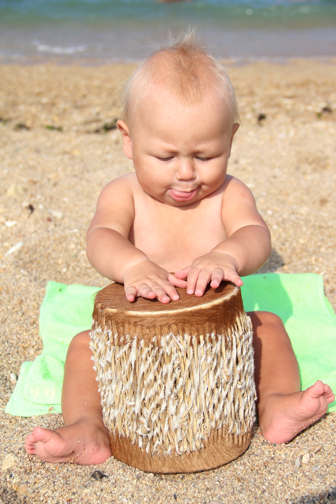 Дитина двох років барабанить на пляжі