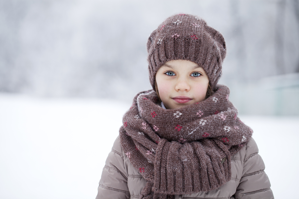 Девочка зимой в широком шарфике и шапке