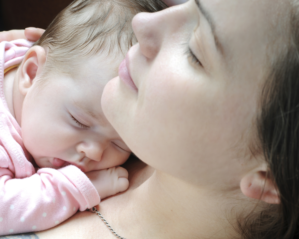 Немовля спить на грудях у мами