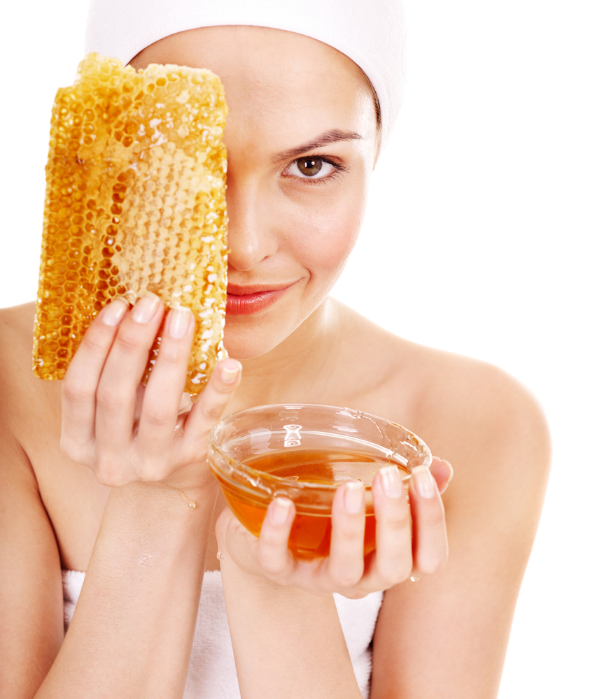 Девушка держит мед и наносит его на лицо