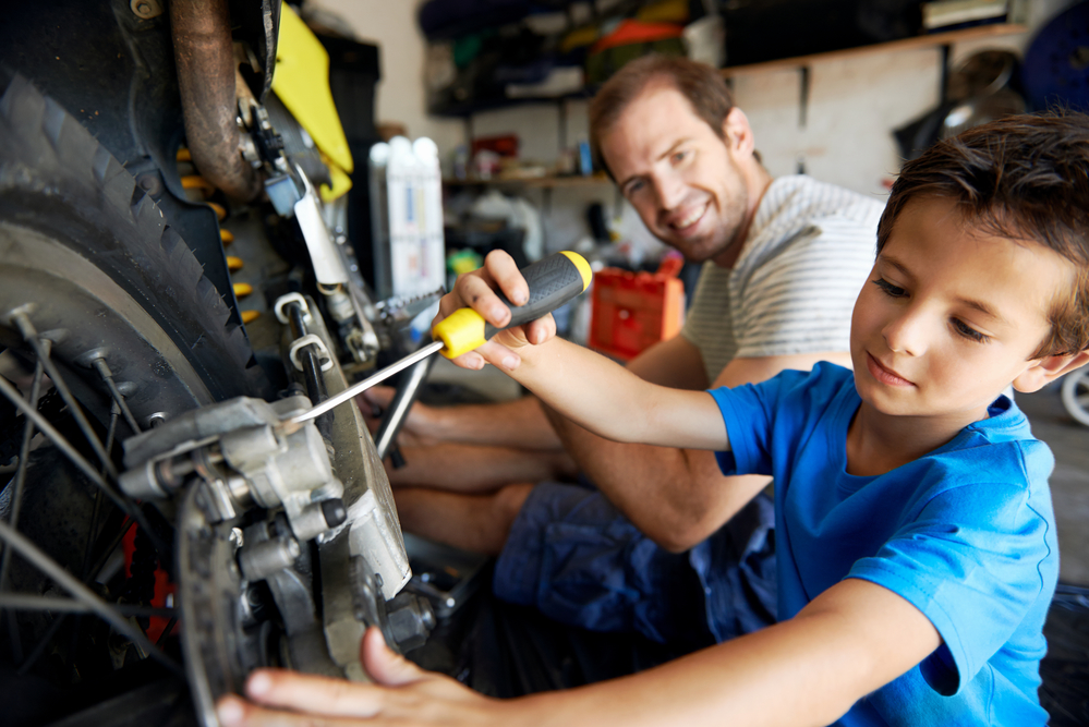 Папа с сыном ремонтируют технику в гараже