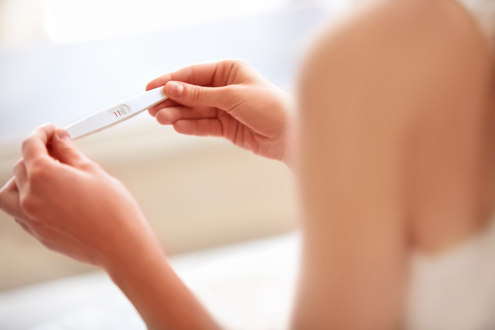 Жінка тримає тест на вагітність