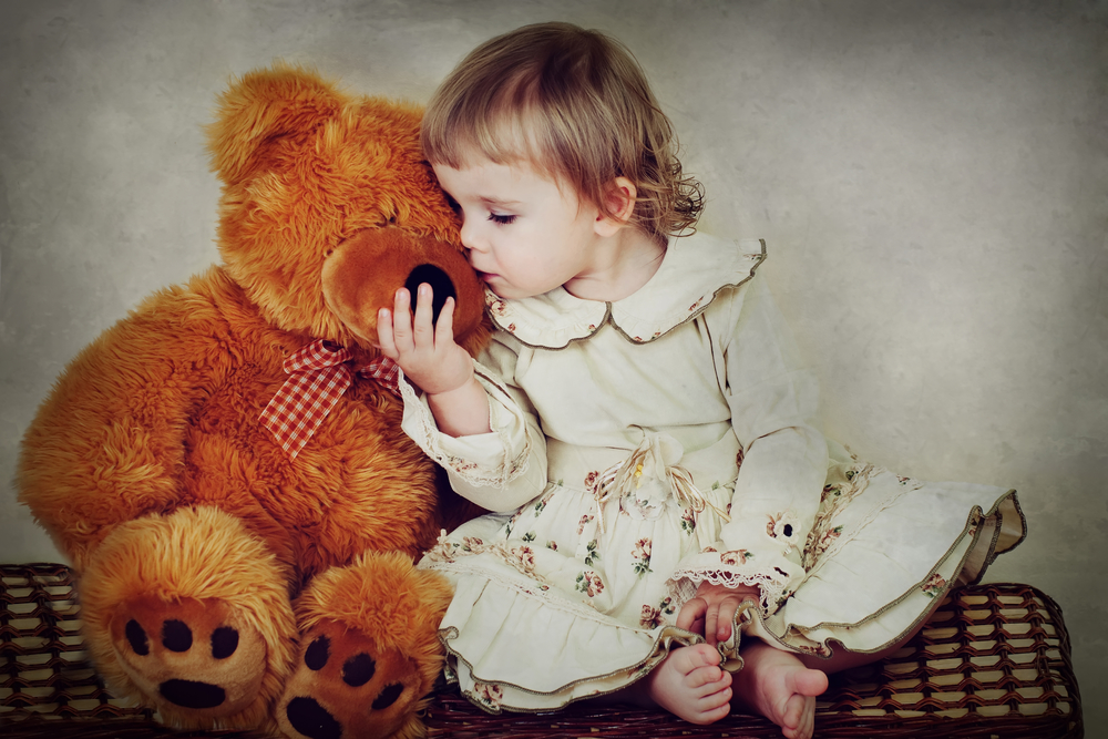 Девочка целует игрушку - мишку