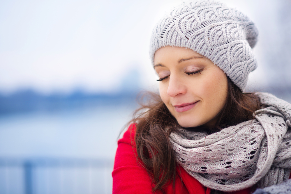 ​  Жінка взимку в шапці і шарфику