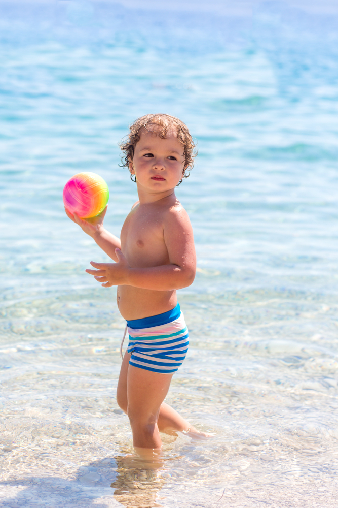 Ребенок на пляже купается в воде