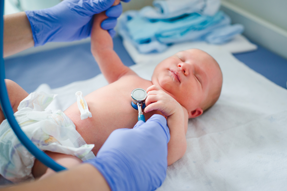 Неонатолог проверяет рефлексы новорожденного