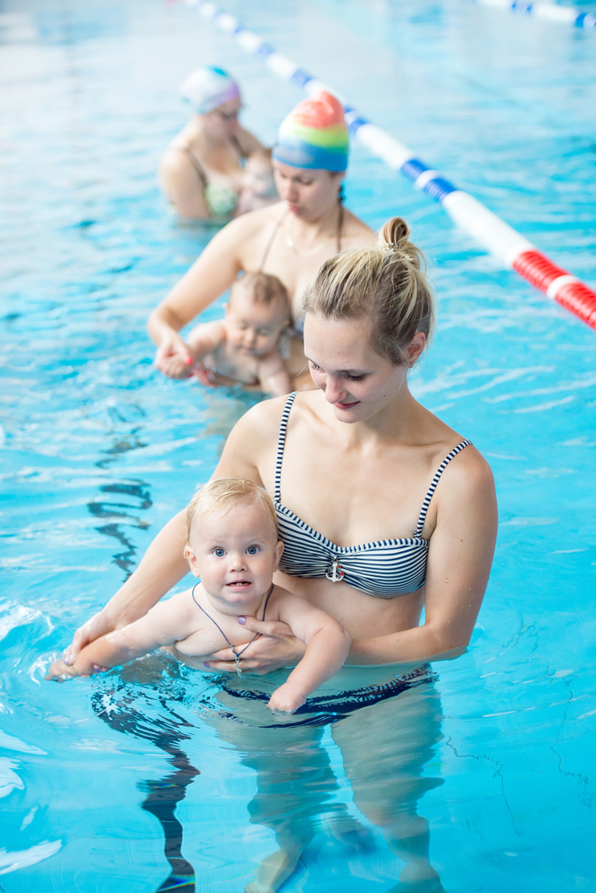 мама вчить плавати дитину 