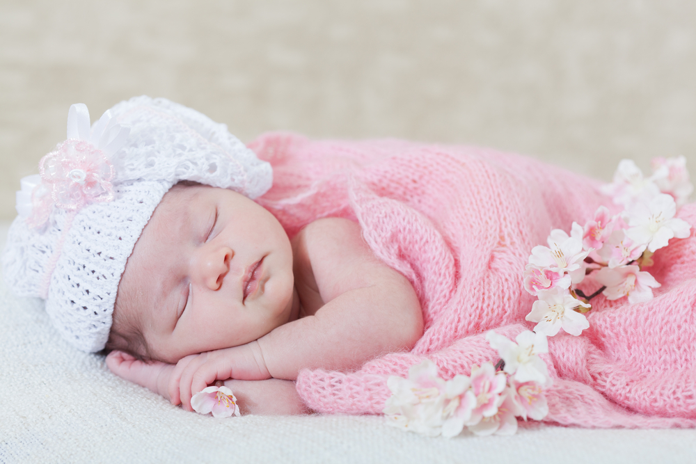 Маленькая девочка спит под шерстяным одеялом
