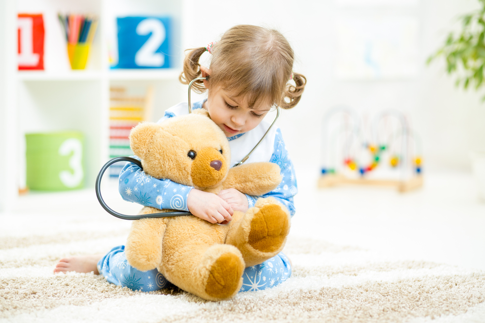 Дівчинка в дитячому садку лікує ведмедика