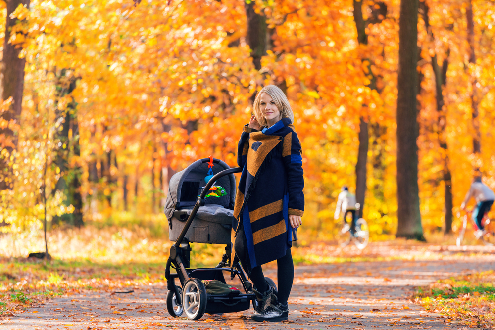 Стильная мама на прогулке с коляской осенью