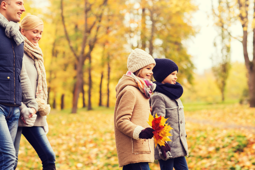  Сім'я гуляє парком - батьки і двоє дітей на осінній прогулянці
