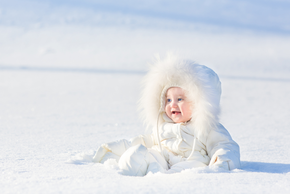 Малыш в теплом комбинезоне на снегу