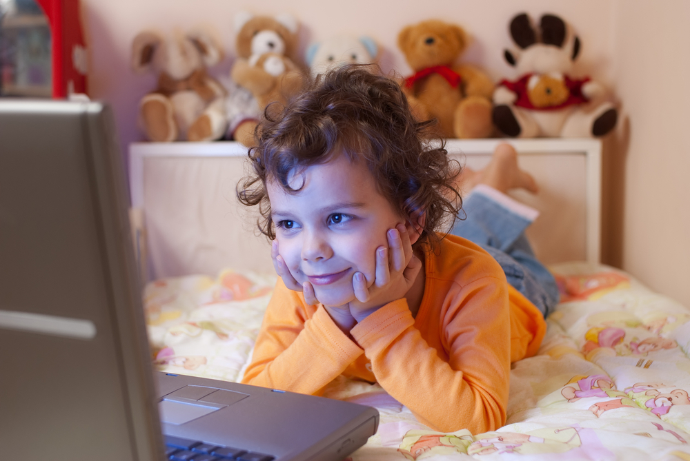 Малыш смотрит мультфильмы на ноутбуке