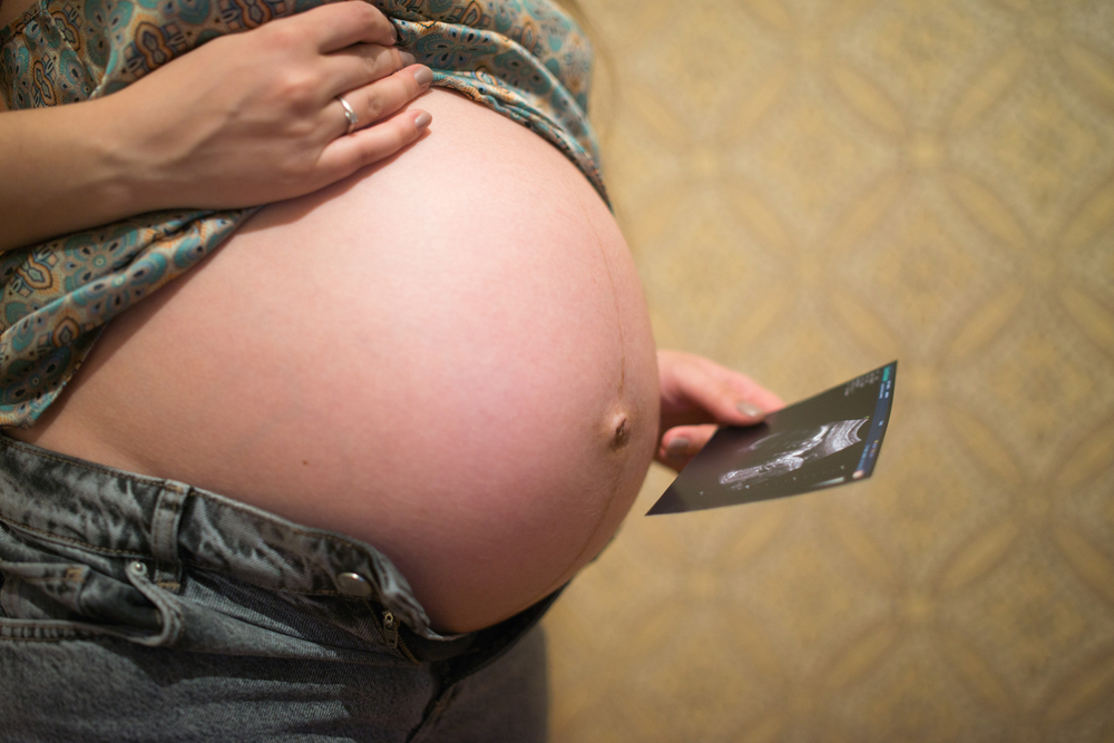 Беременная смотрит на результат обследования УЗИ своего малыша