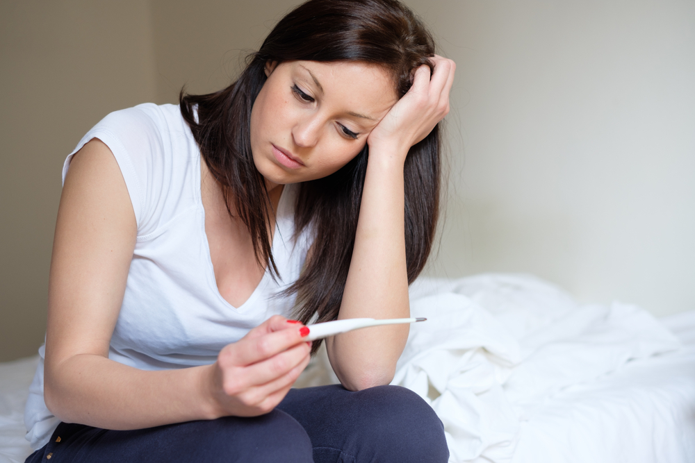 Расстроенная девушка с тестом на беременность