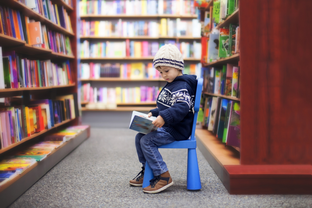 Ребенок читает в библиотеке