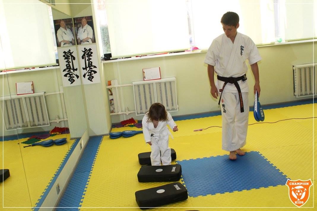 Ребенок занимается каратэ  с тренером