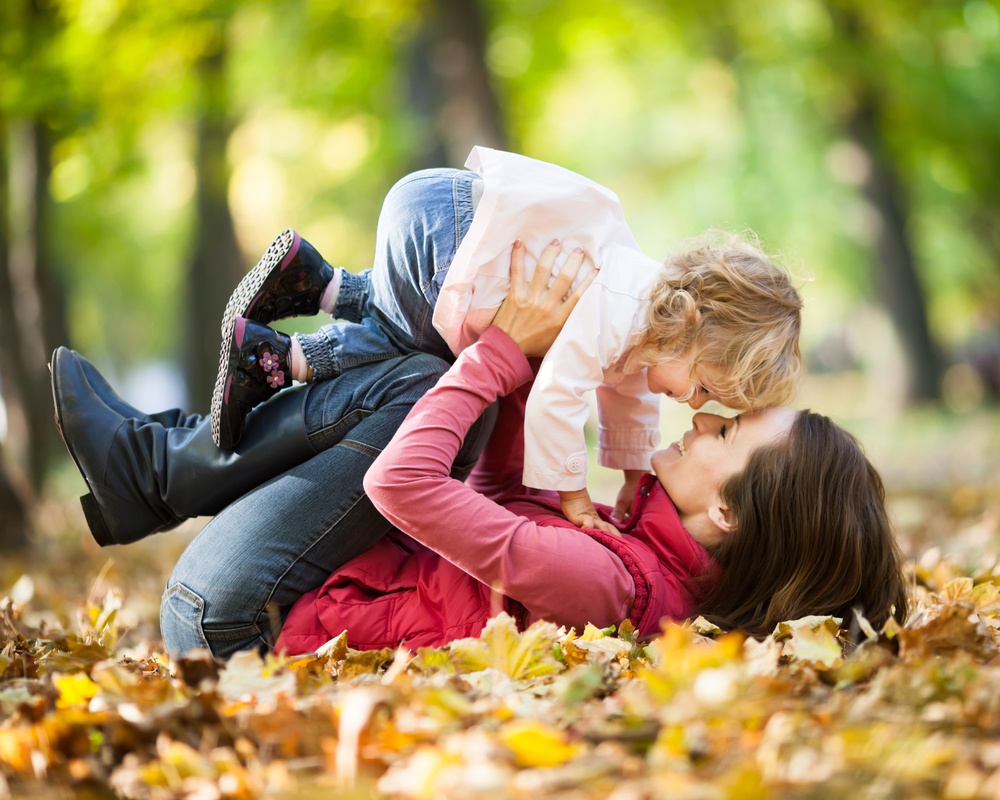 Мама с ребенком в парке осенью