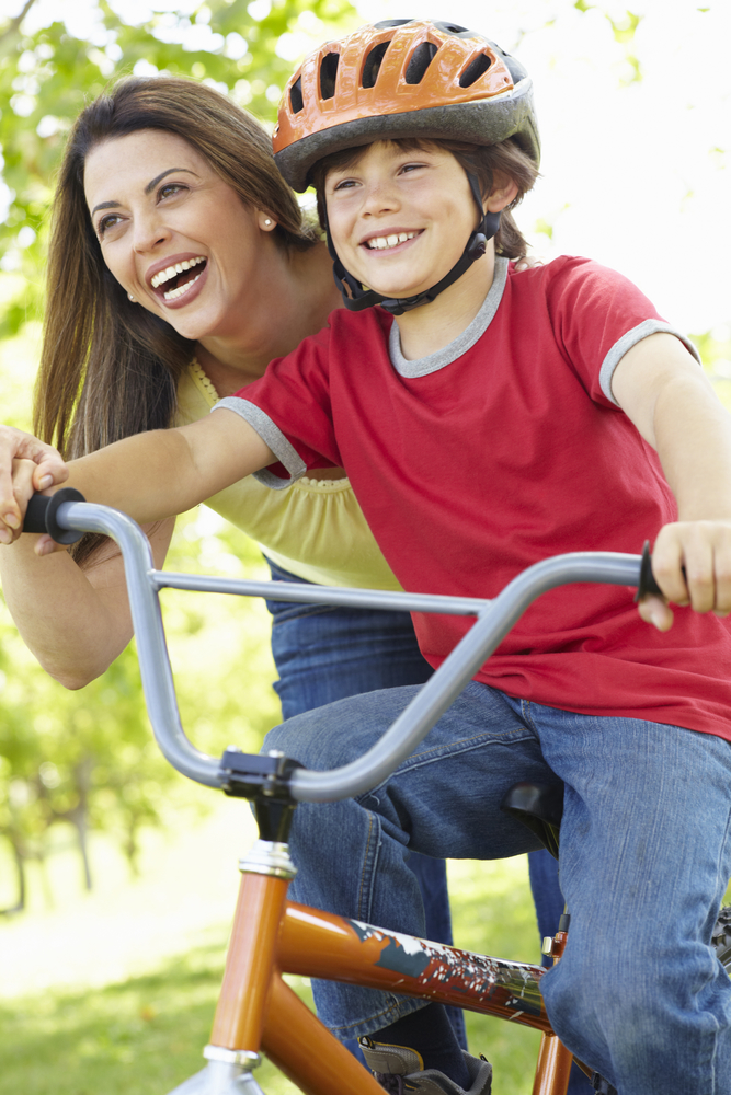 Мама учит ребенка кататься на велосипеде
