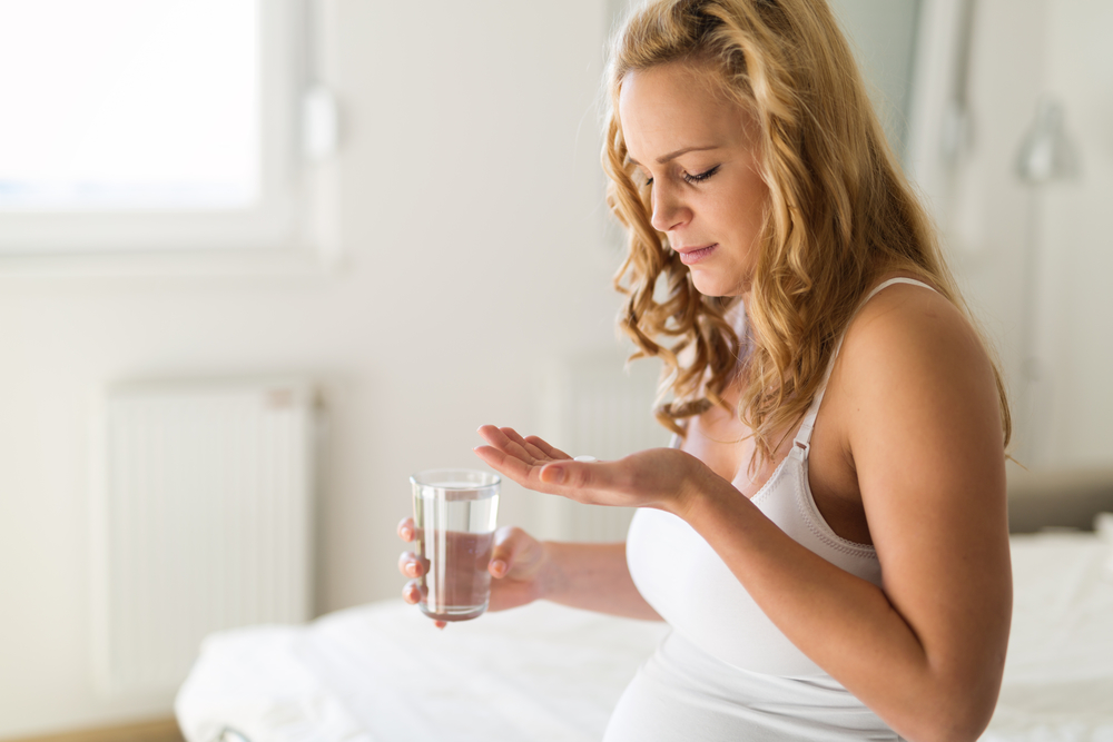 Беременная пьет лекарство