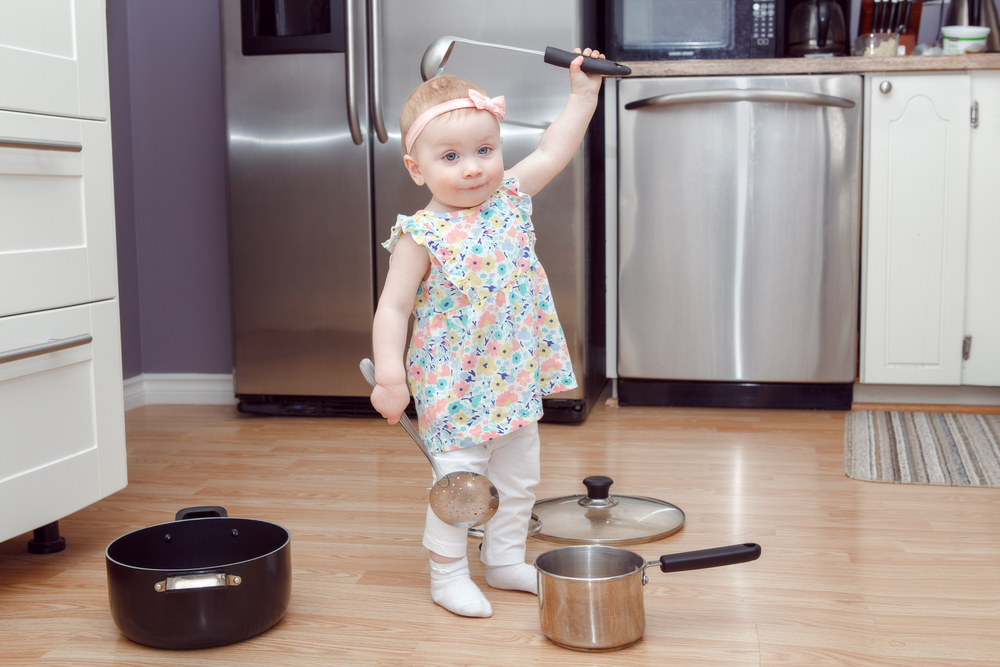 Крихітка на кухні грає каструлями