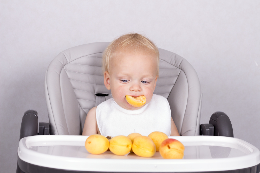 Малыш ест абрикосы