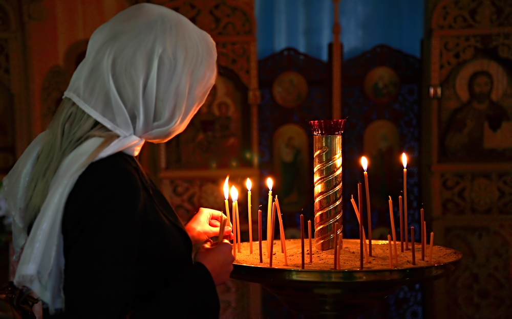 девушка в церкви молится на день Николая Чудотворца