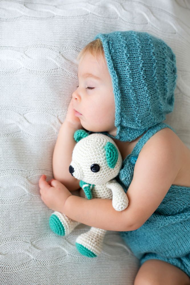 малюк спить з іграшкою для засинання