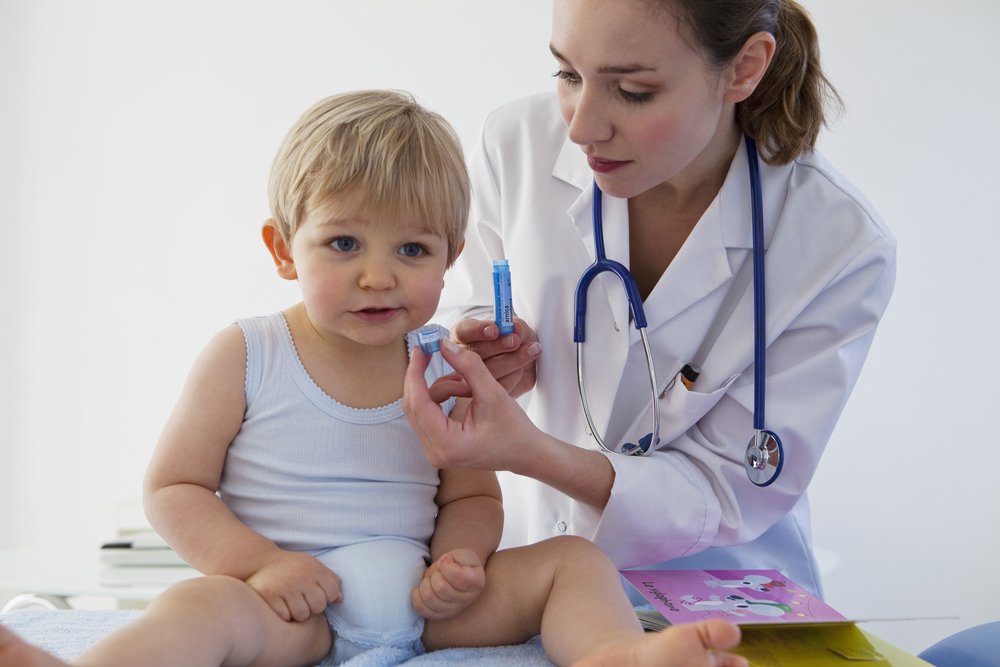 Доктор лечит ребенка гомеопатическими препаратами