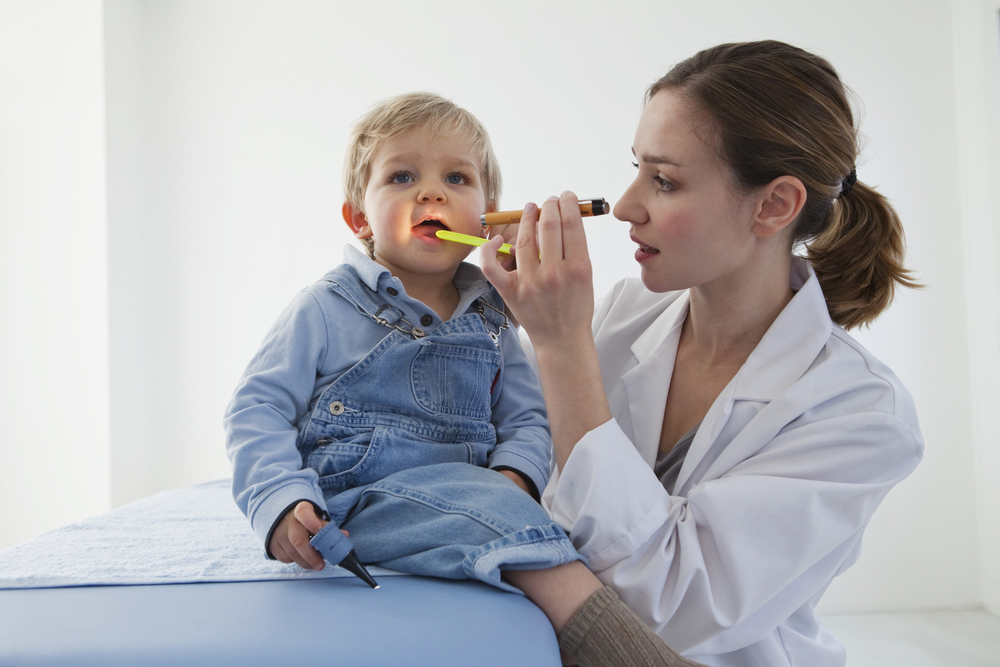 Доктор проверяет горло малыша